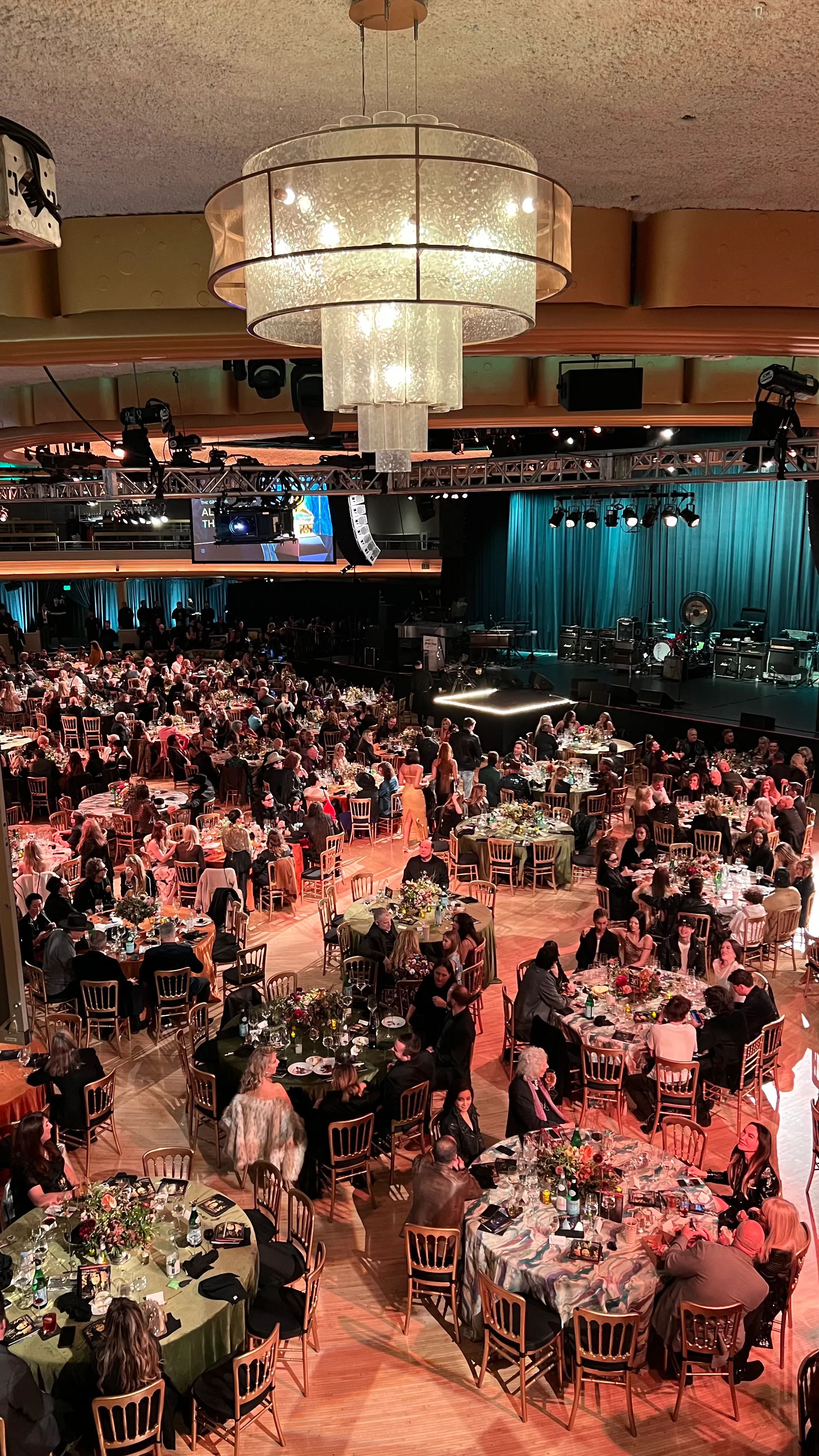Packed ballroom gala with warm table lighting and a stage set for the evening program