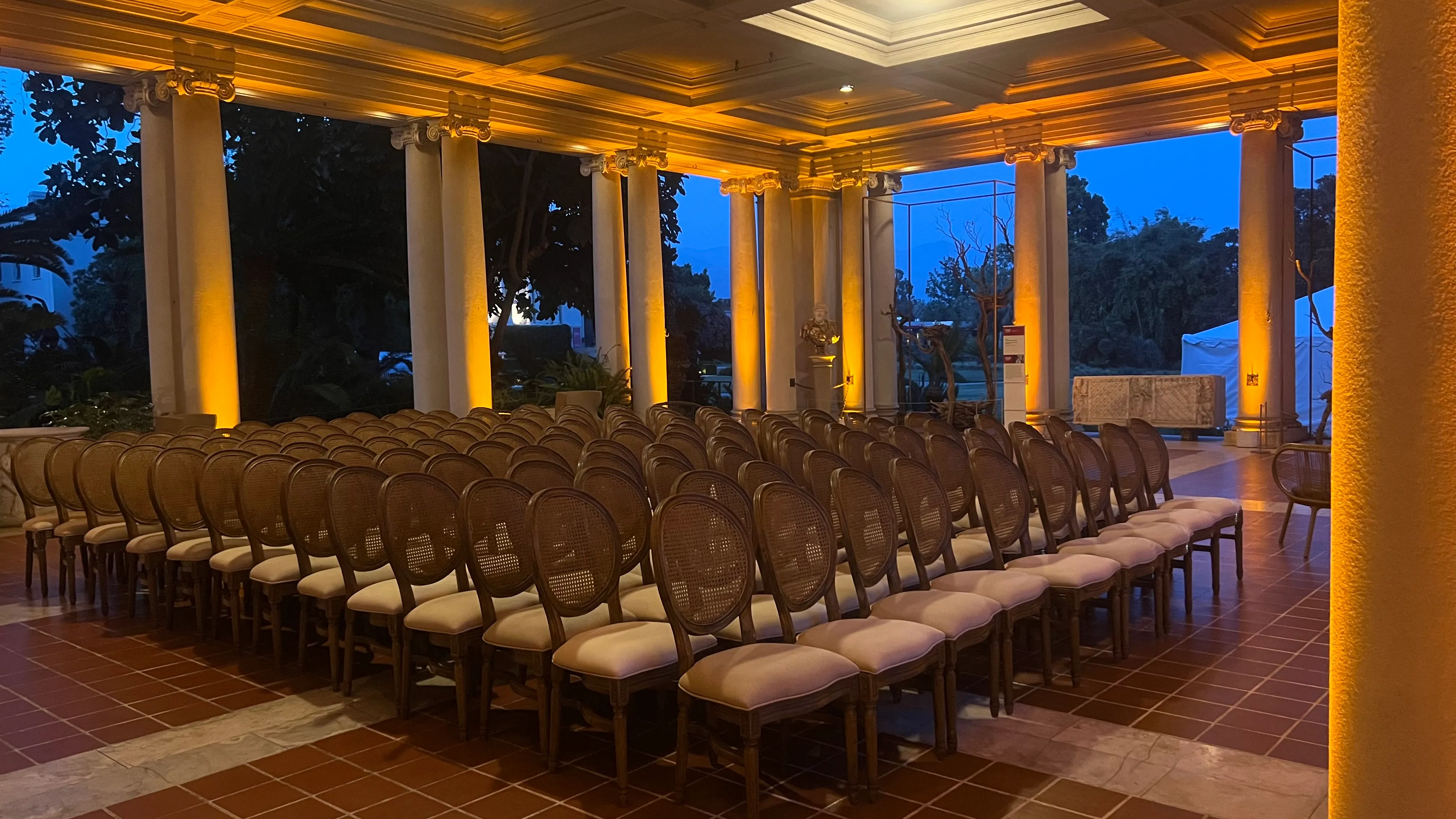 Historic columned terrace washed in warm amber uplighting at dusk for a Los Angeles event