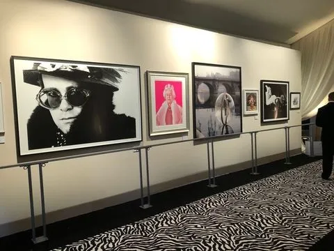 Framed artwork accent-lit along a gallery wall at a benefit event