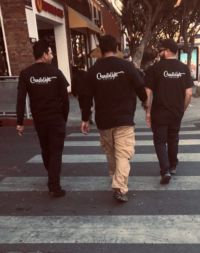 Three Candlelight Designs, Inc. crew members in company shirts walking to an event site